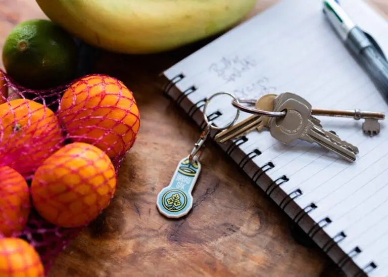 Branded recycled trolley stick keyring in white with printed logo attached to keys